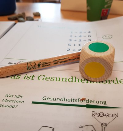 Ein Blatt Papier auf dem ein Farbwürfel und ein Stift liegt