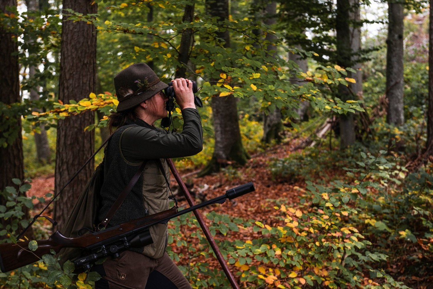 Person mit Jagdequipment steht im Wald