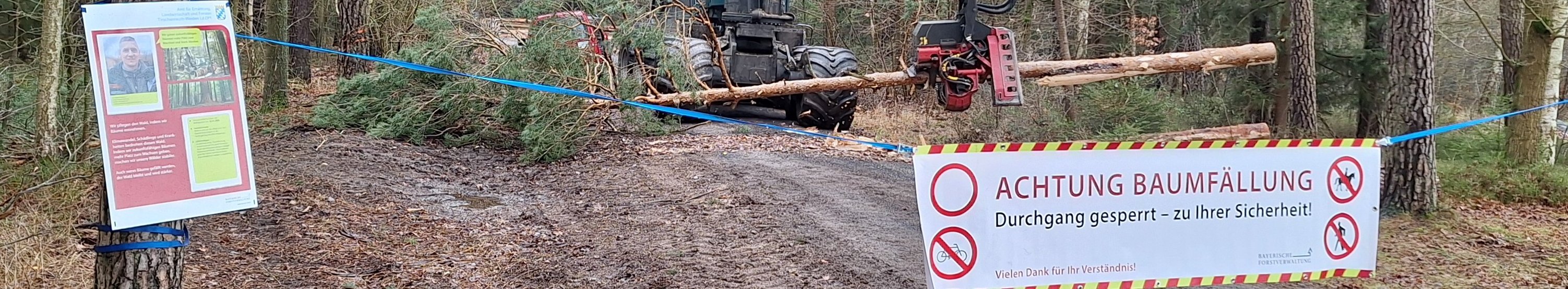 Harvester auf Forstweg hinter einem Absperrbanner