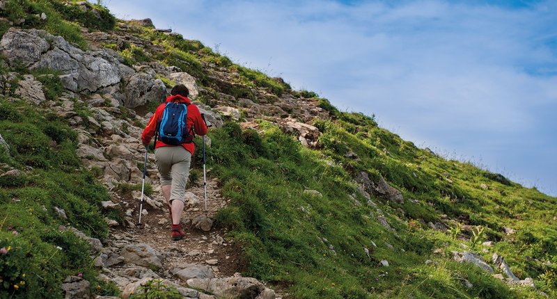 Wanderer geht einen Bergpfad hinauf
