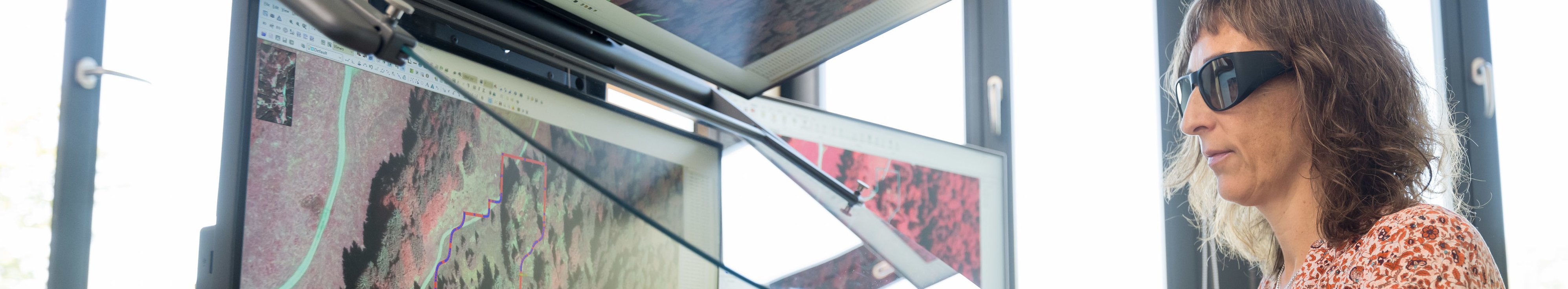 Eine Frau schaut auf mehrere Monitore