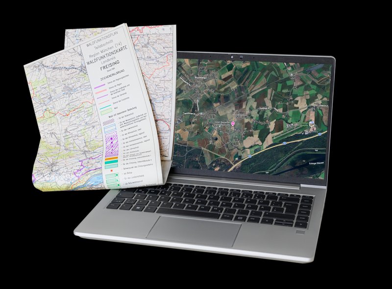Laptop und Papierlandkarte