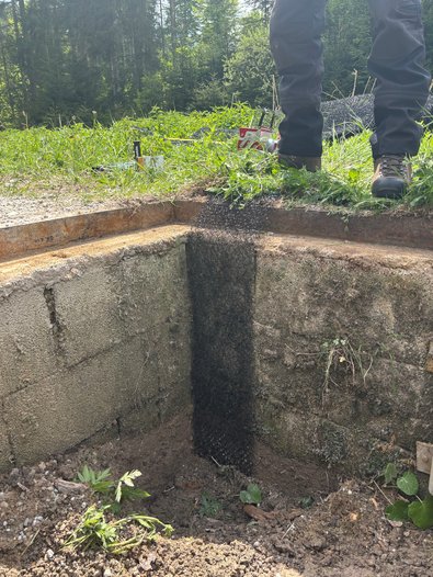 Ein Streifen Kunststoffgewebe hängt in eine Grube